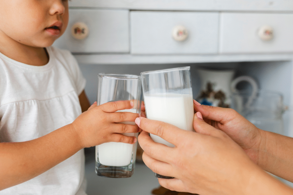 ibu dan anak memegang segelas susu