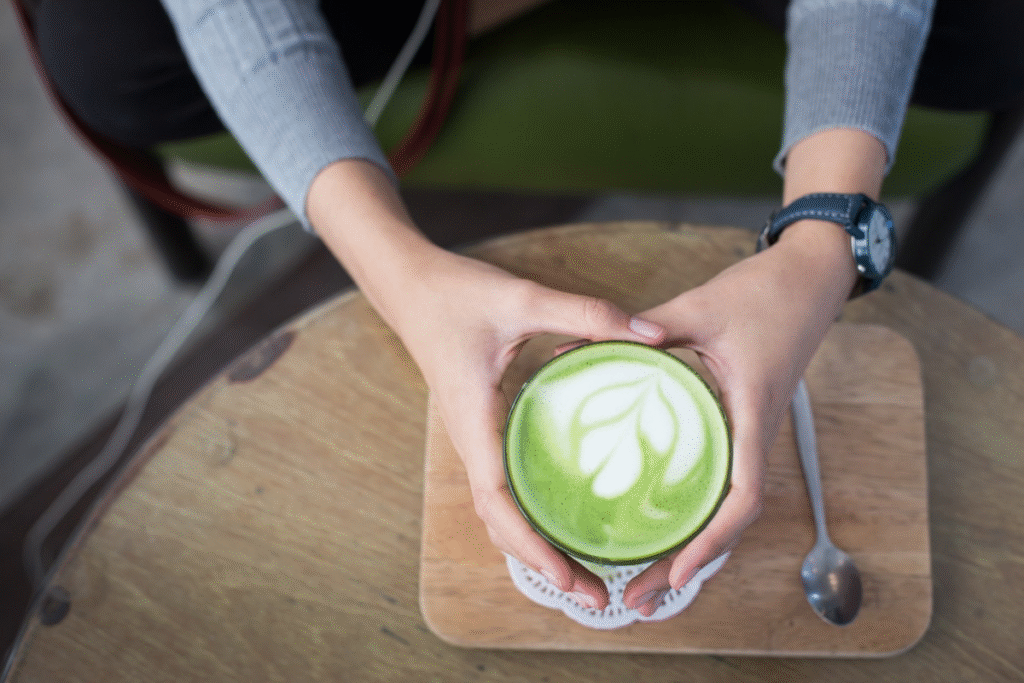 orang yang memegang segelas matcha latte