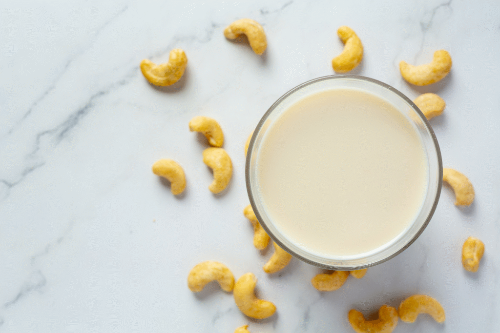 segelas susu dan kacang mede di sekitarnya