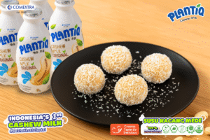 Piring hitam dengan klepon coklat dan Plantiq Cashew Milk
