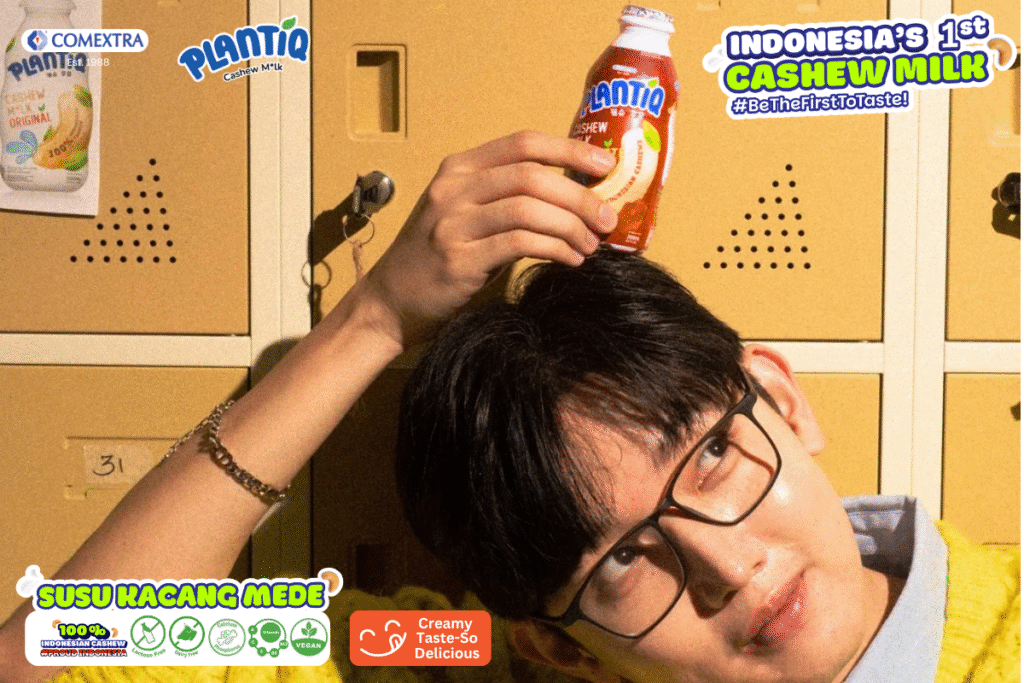 Pria berkacamata memegang sebotol PLANTIQ Cashew Milk