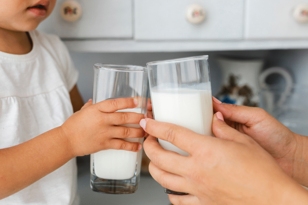 Seorang ibu dan anak yang sedang memegang segelas susu
